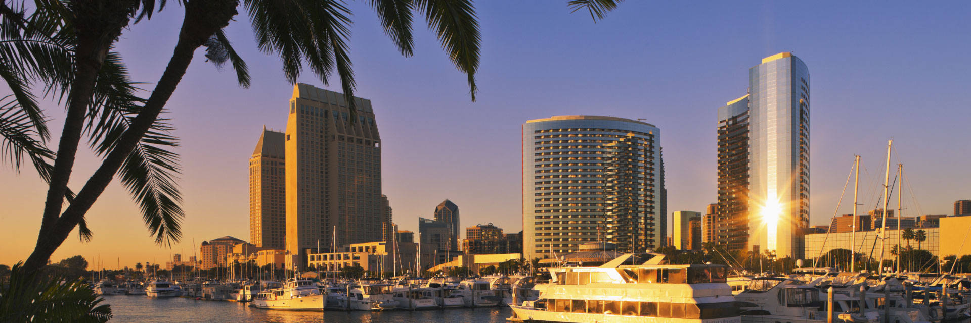 Sun setting over buildings and harbor